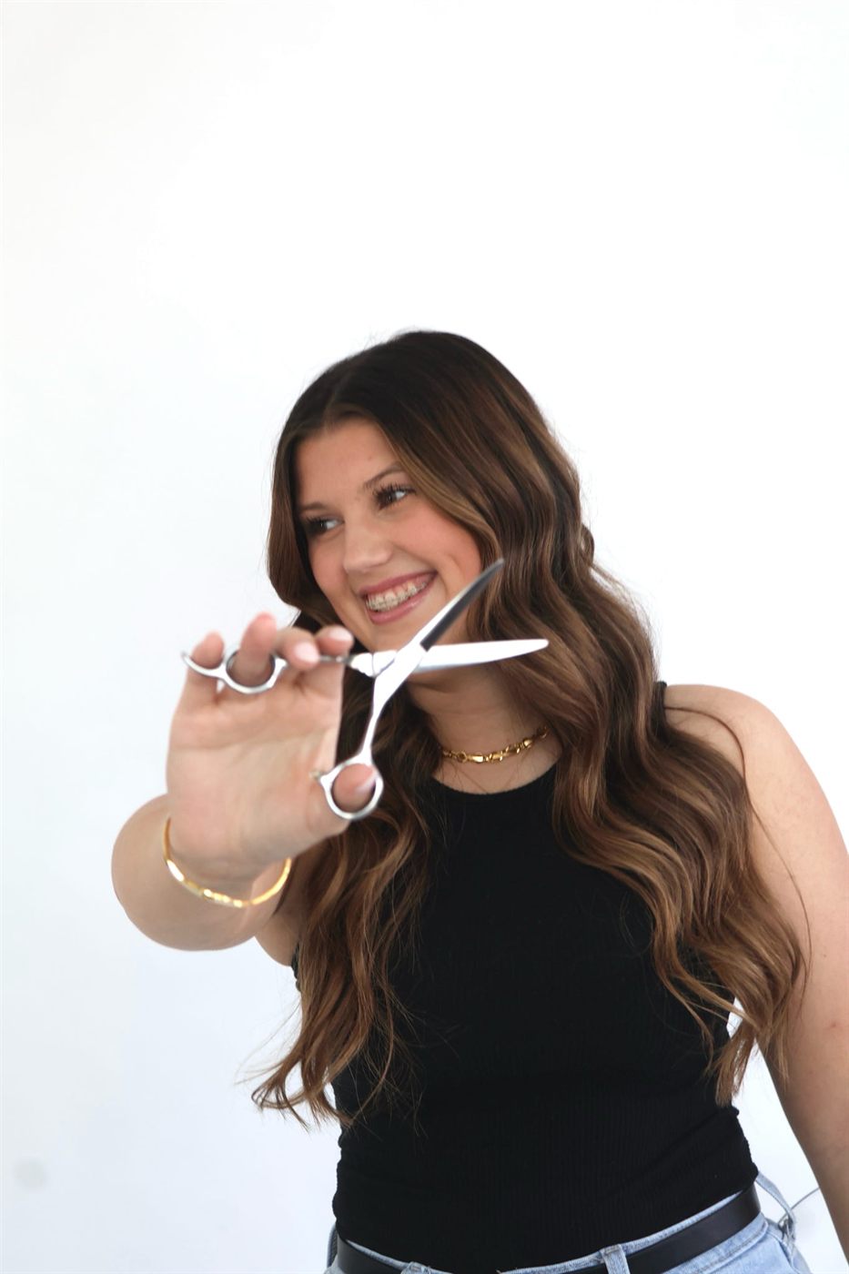 Madison smiling and holding her styling shears